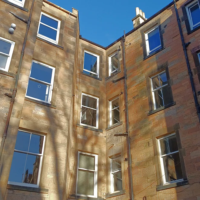 Tenement close-up showing timber sash and case and uPVCwindows in their box frames