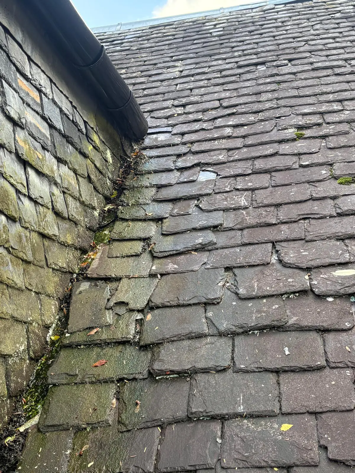 Storm-damaged tenement roof with missing slates